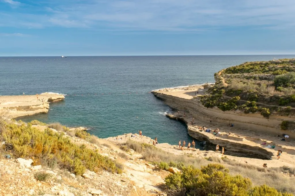 view of St. Peter's Pool from above with swimmers around the edges, what to do in malta