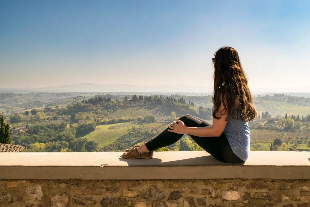 kate storm overlooking the tuscan countryside from san gimignano in the fall, one of the best places to visit with 3 days in tuscany itinerary