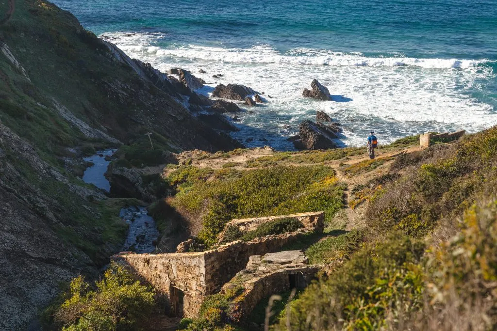 man hiking along the rugged fishermans trail on a rural section of the algarve, an offbeat european destination to visit