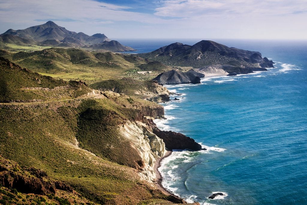 rugged landscape of cabo de gata natural park in spain, one of the best offbeat europe destinations to visit. water is to the right of the photo