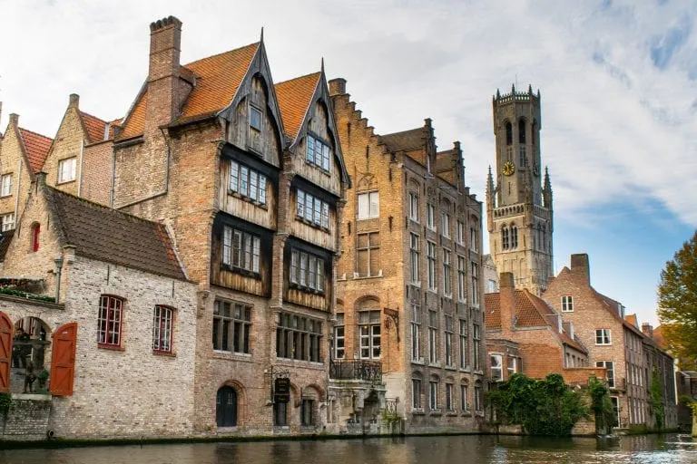 view of a wooden building along a canal in bruges belgium. canals are a big draw of bruges or ghent belgium