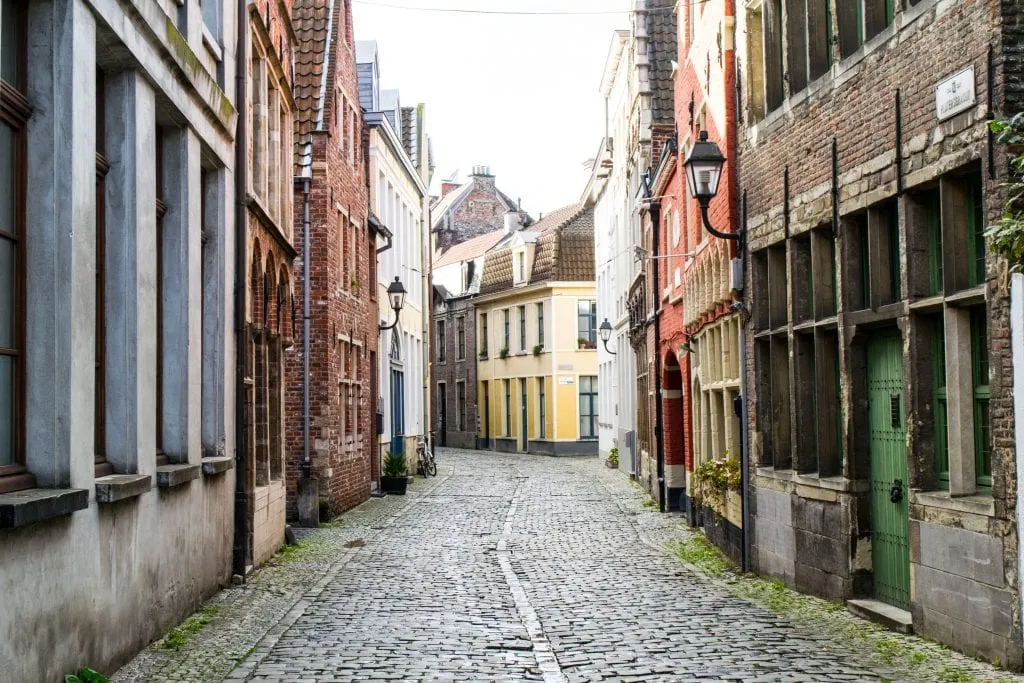 traditional flemish buildings lining an empty cobblestone street in patershol ghent