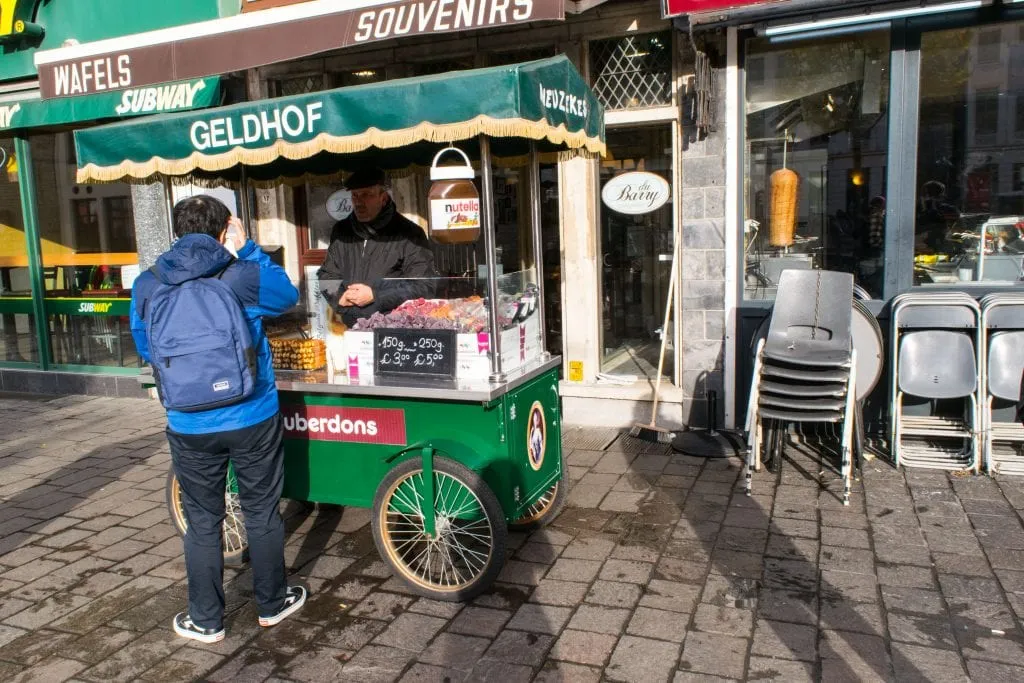 man purchasing candy from a street vendor during one day in ghent belgium