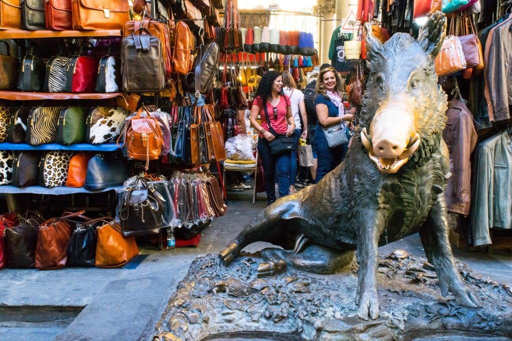 porcellino statue in florence italy with leather goods for sale behind it