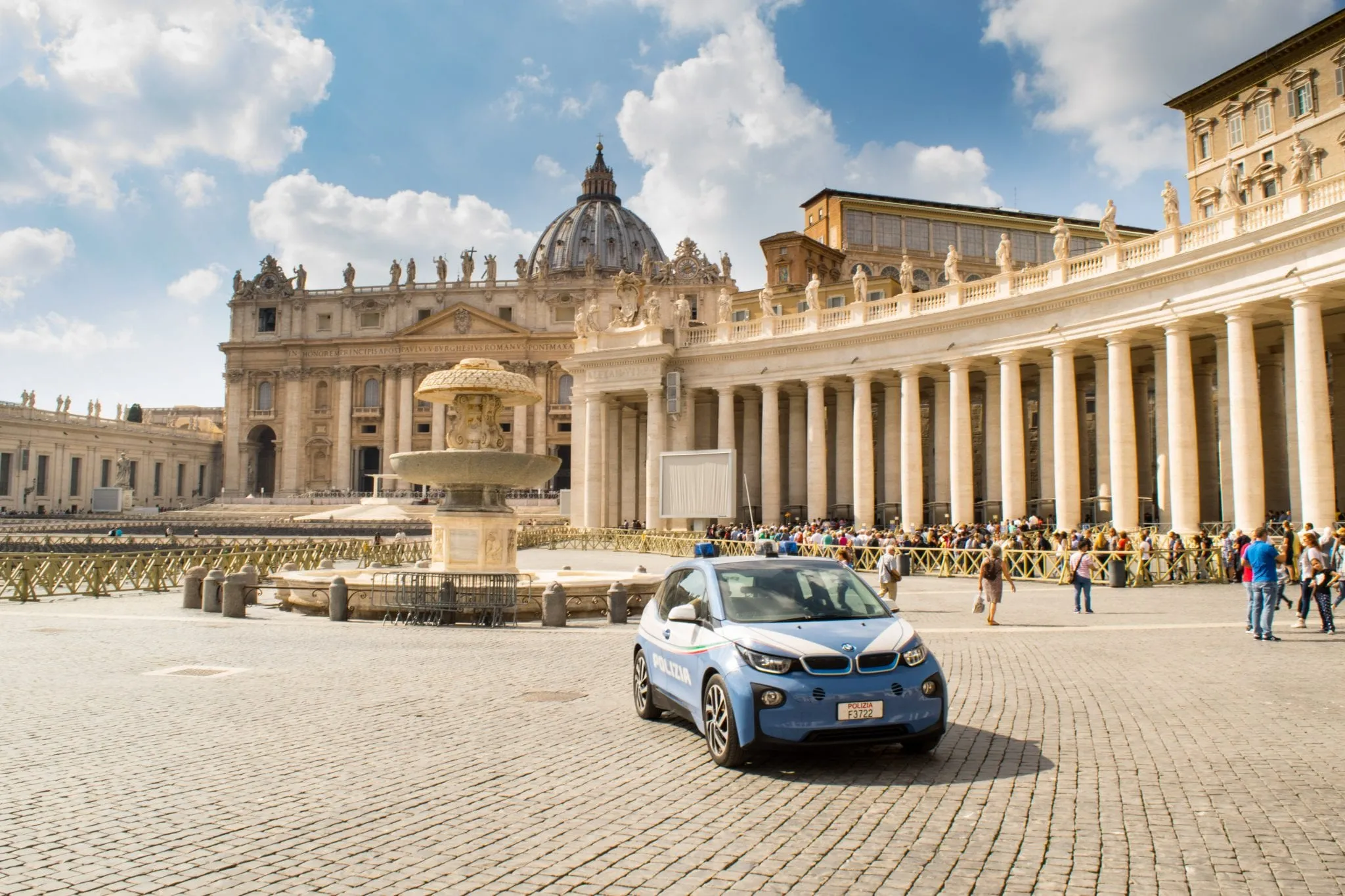 St Peter's Square on sunny day with car parked in the square--checking out this square is a must-see when touring Vatican City!