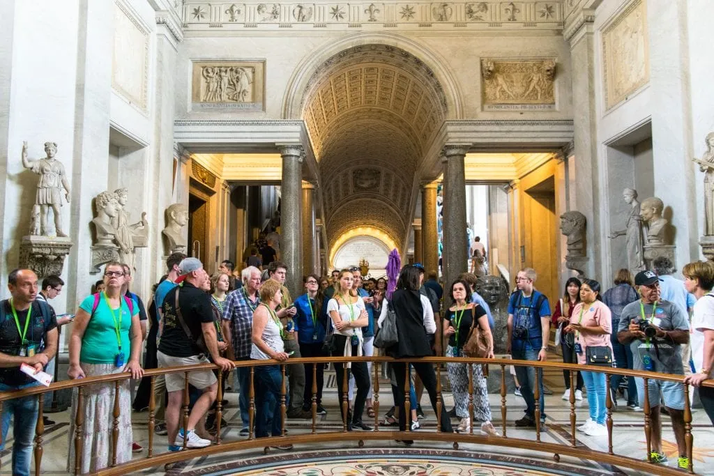 Crowds of tourists visiting the Vatican Museums in Rome, lined up around a barricade
