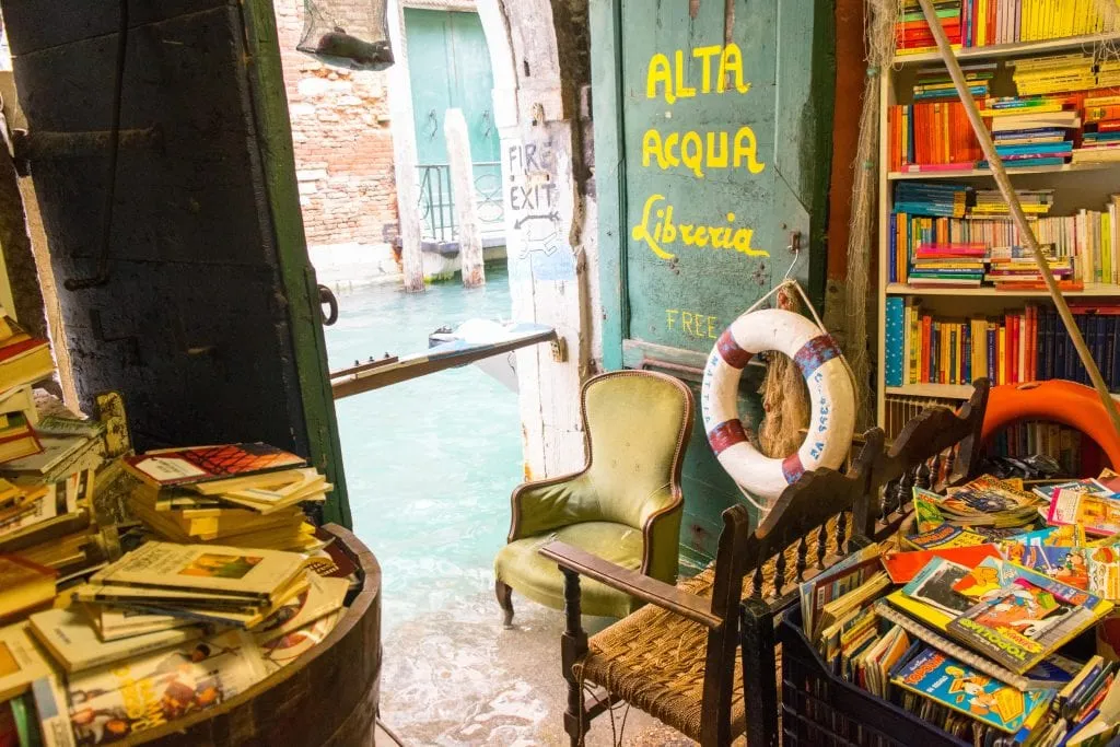 Libreria Acqua Alta Venezia: fire exit during minor acqua alta, there's water visible near the legs of the green chair.