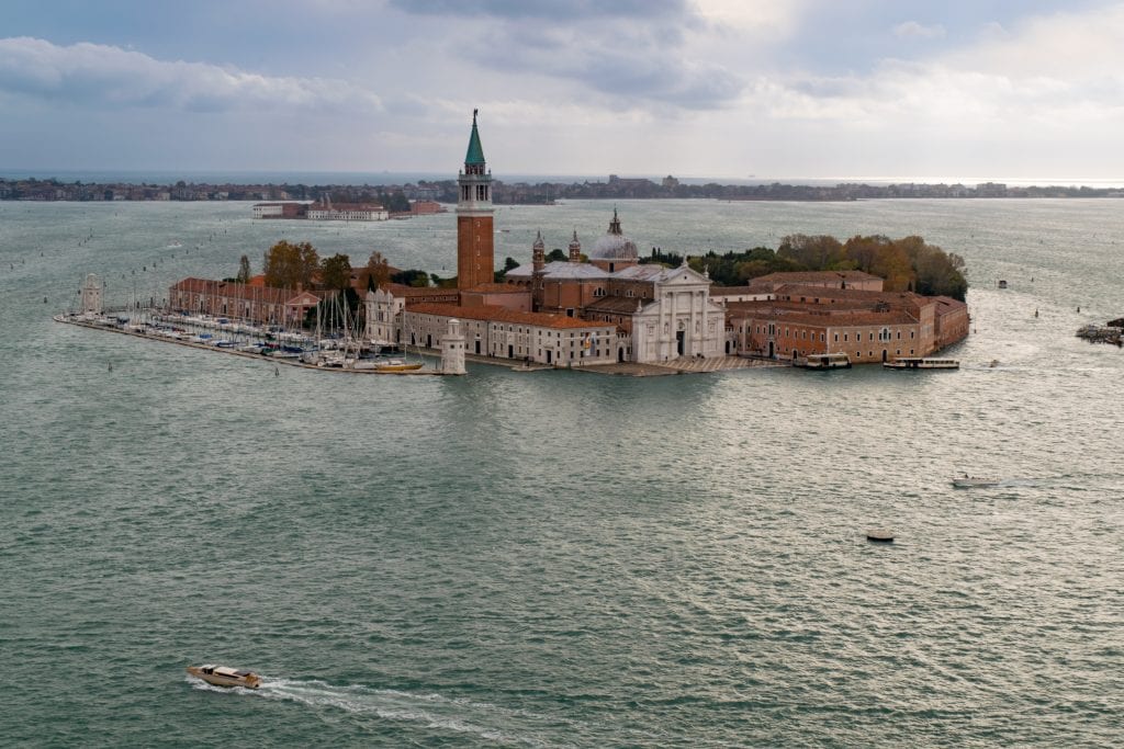 Photo of San Giorgio Maggiore from above surrounded by the Venetian Lagoon--this small island is home to one of the best views in Venice!