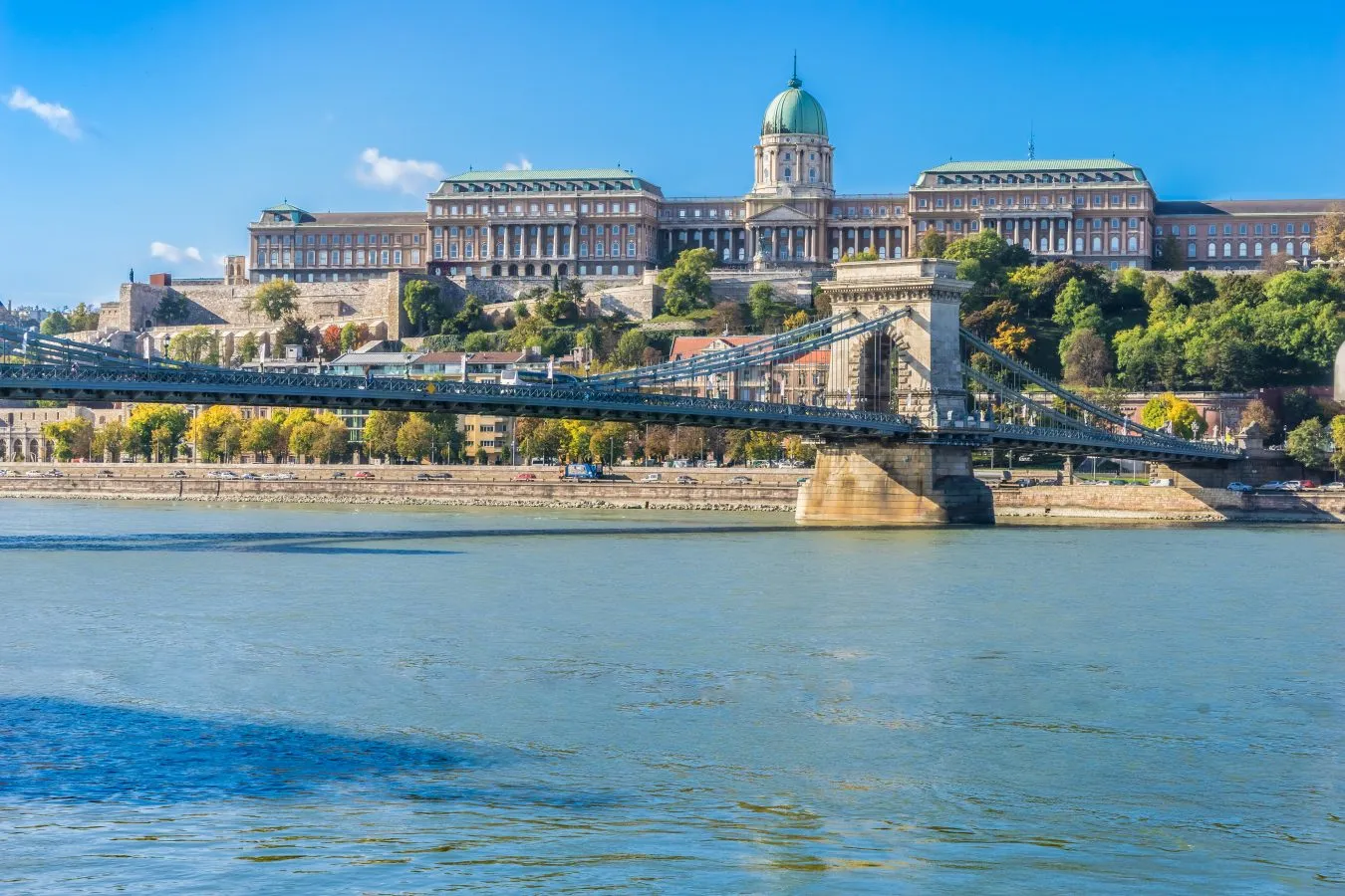view of buda castle with chain bridge and the danube river in the foreground