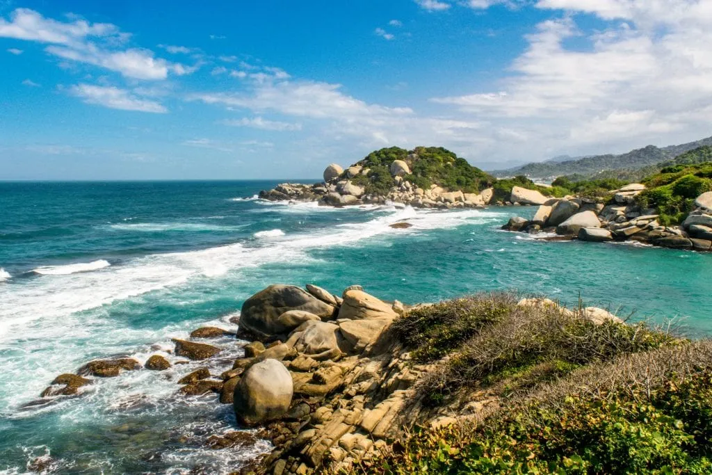 What to Pack for Colombia: Tayrona National Park Beach as seen from above with rocky coast in the foreground