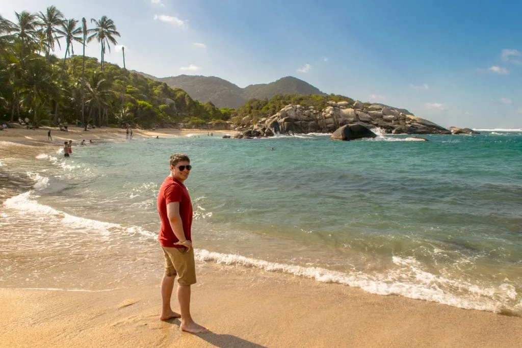 jeremy storm on a beach in colombia, about a year and a half after saving money to travel the world