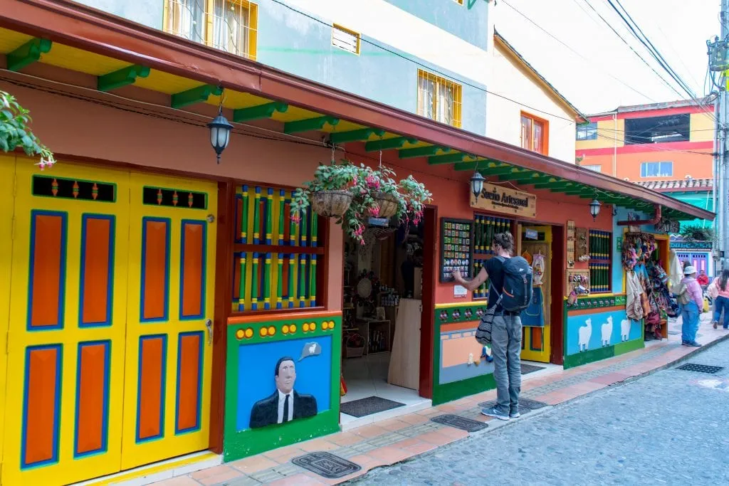 man looking at a menu outside a store in guatape colombia