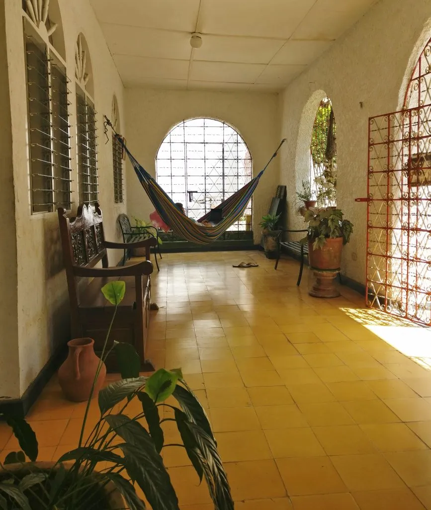 front porch of a hostel in minca colombia with a hammock hanging from the walls