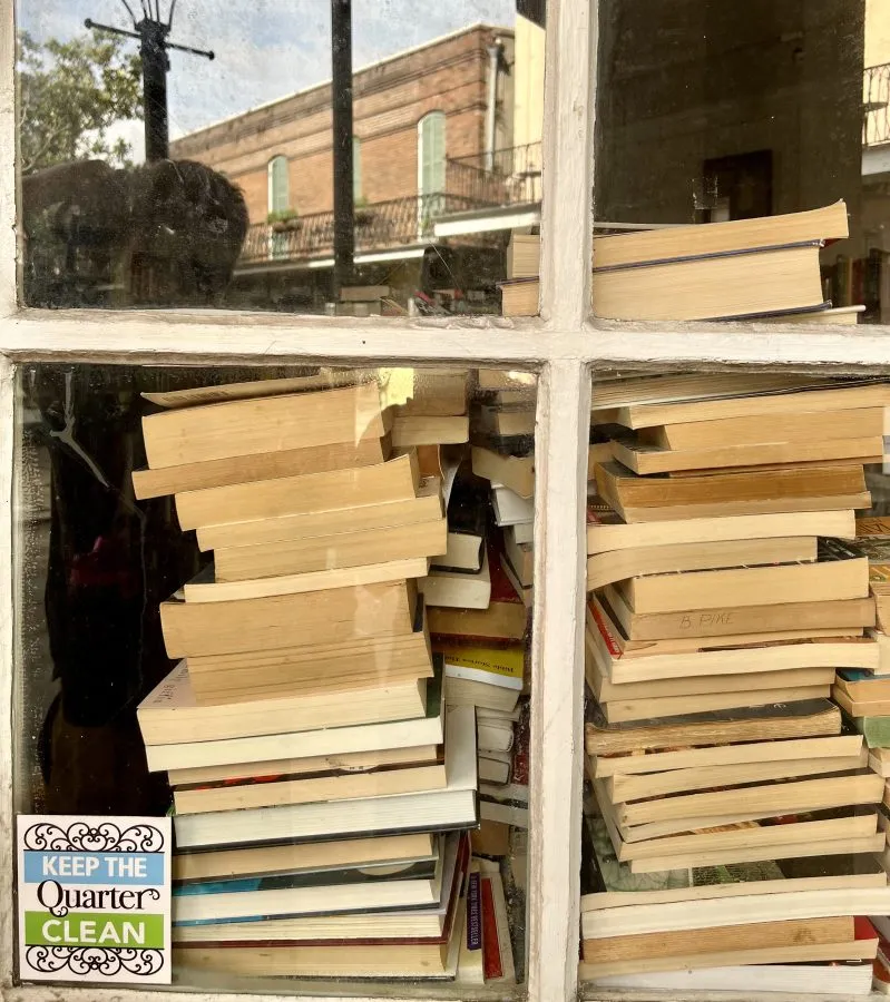 stack of used books in a window in the french quarter in new orleans