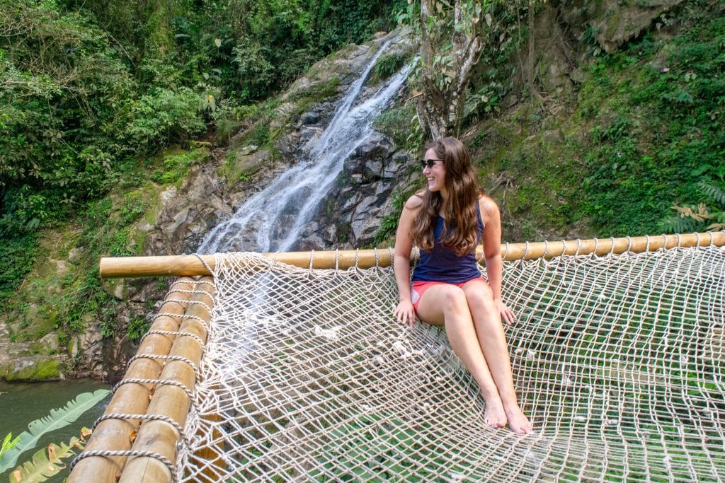 kate storm posing on a hammock at marinka falls, one of the best waterfalls in minca colombia