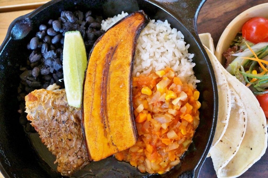 typical costa rican meal on a black plate as seen from above. when deciding costa rica vs nicaragua, the food isn't a deciding factor