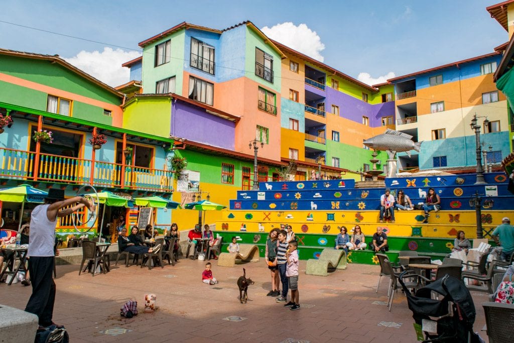 street performer showing off for a small crowd in the colorful town square of Guatape Colombia--don't miss this square when looking for the best things to do in Guatape Colombia