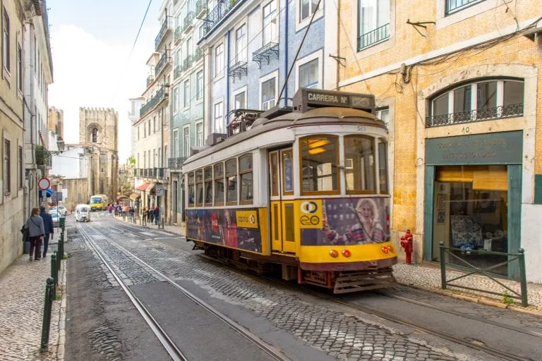 yellow tram passing throuh alfama, one of the best things to see on a lisbon itinerary