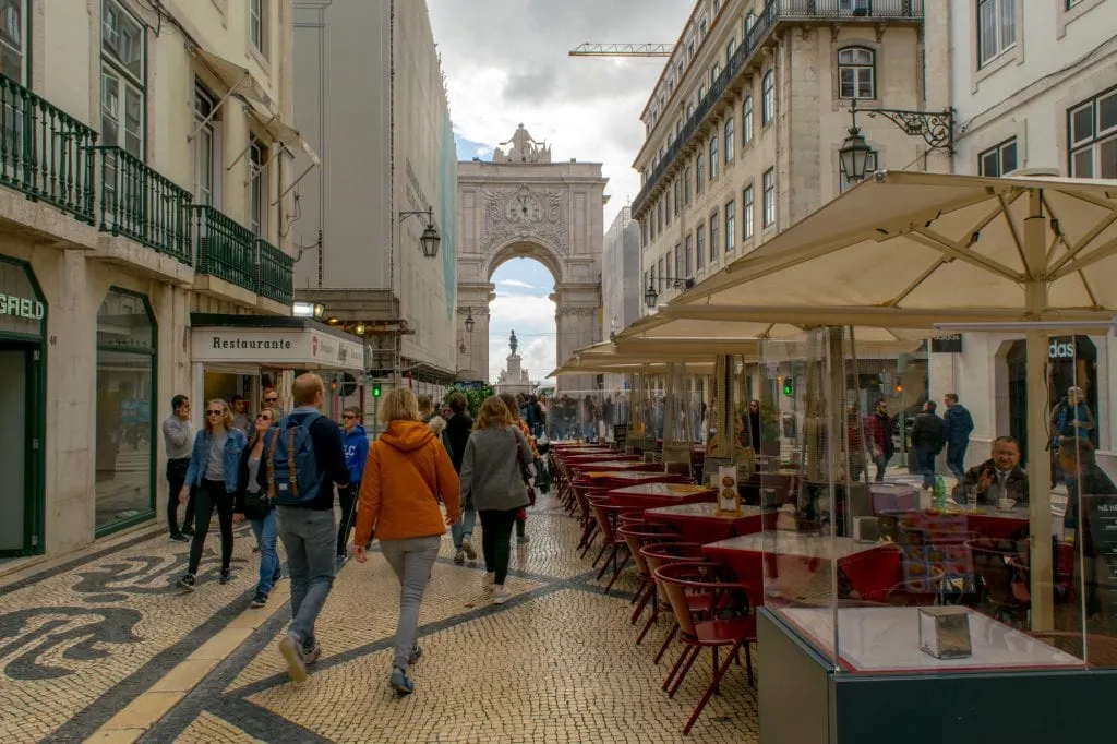 people walking through baixa toward the arch when visiting lisbon march