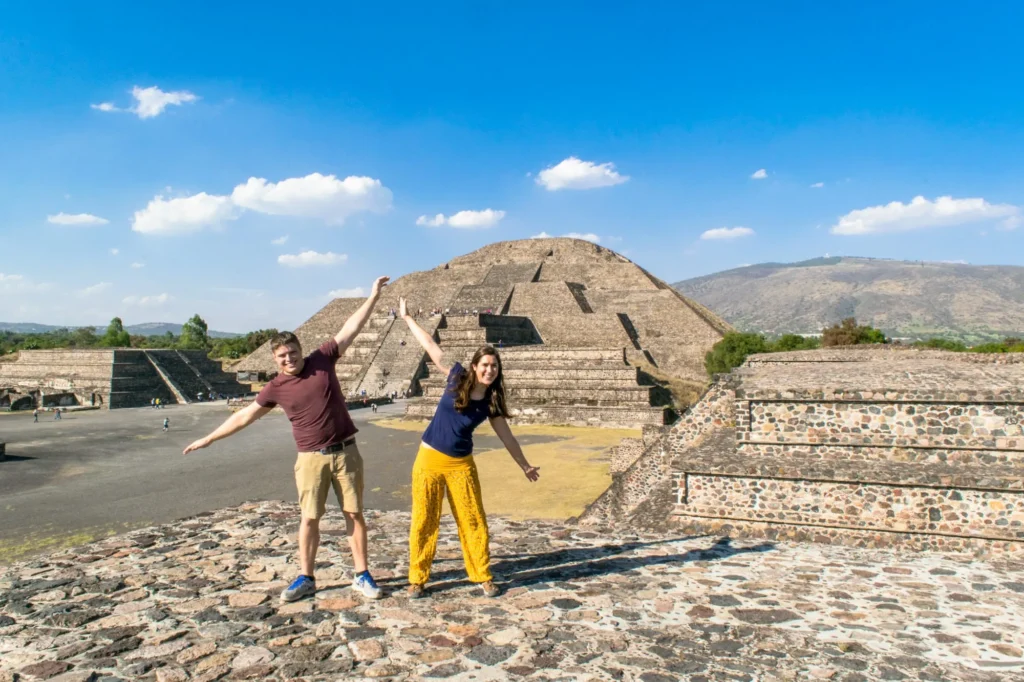 kate storm and jeremy storm standing on top of a pyramid in teotihuacan mexico on a day trip from visiting Mexico City in 3 Days