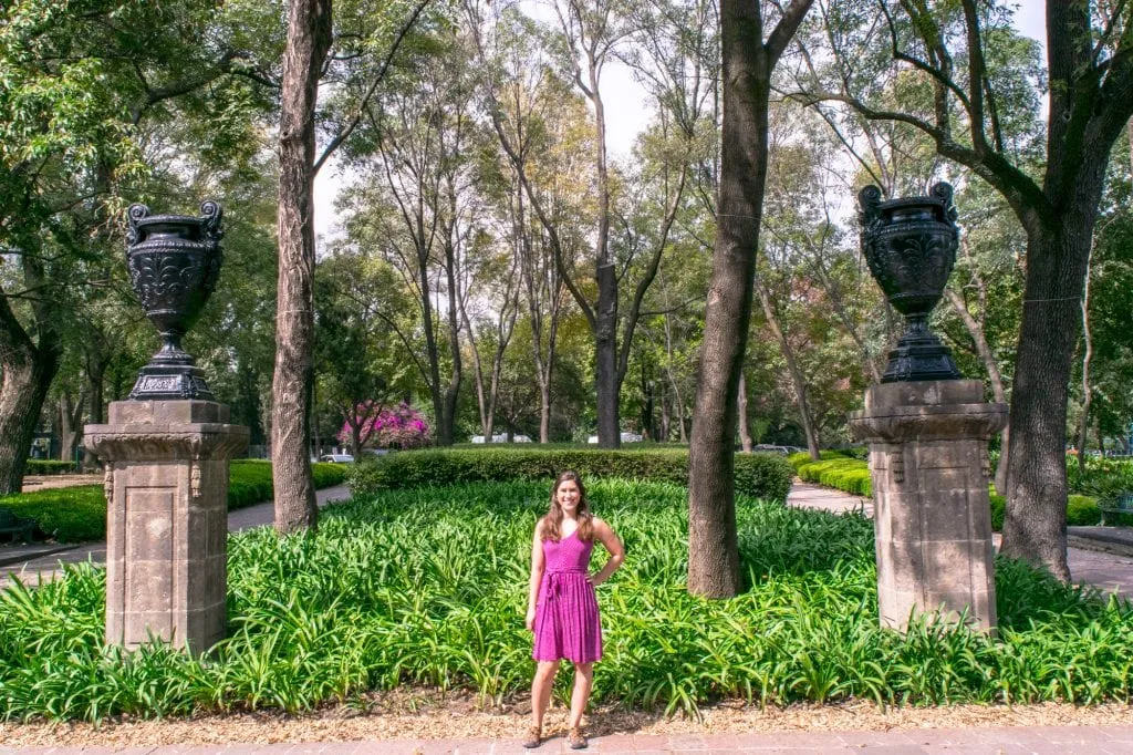 kate storm in a pink dress standing in chapultepec park during a trip to mexico city