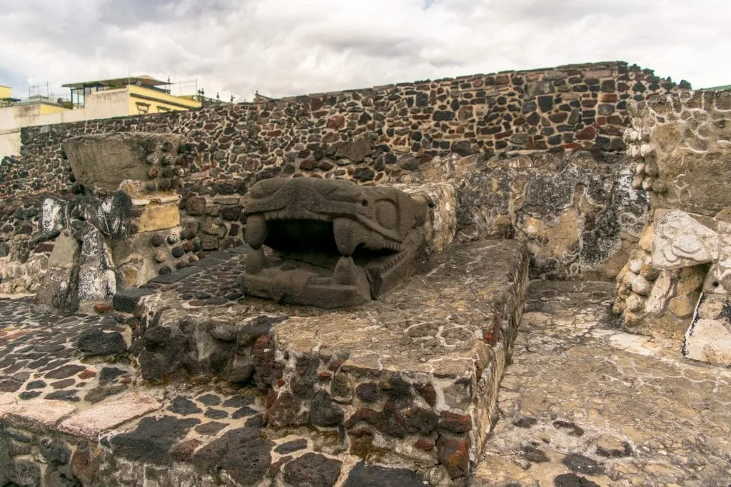 statue of a snake head at templo mayor in the heart of mexico city