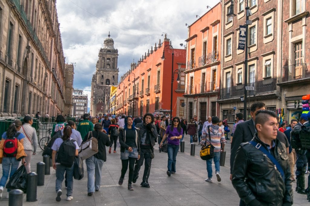 crowds of tourists on a colorful street, a common sight during a 3 day itinerary for mexico city