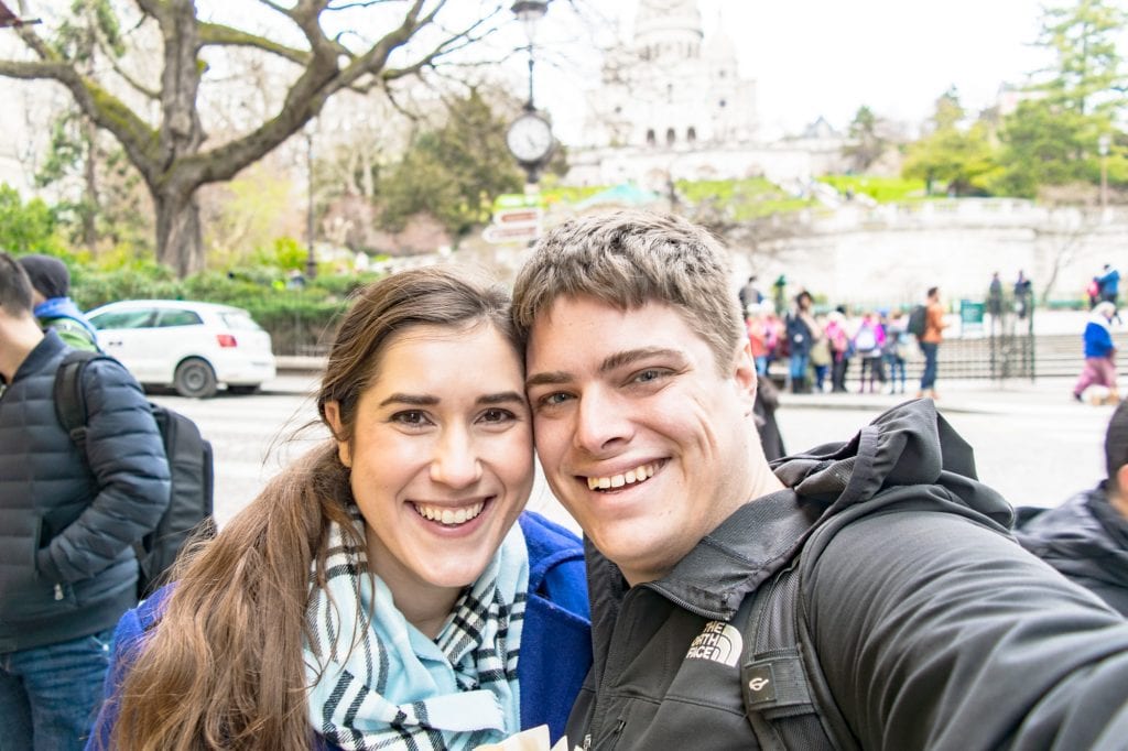 Winter in Paris: Jeremy Storm and Kate Storm taking a selfie in front of Sacre Coeur while bundled up in coats