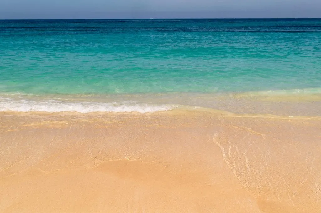 Golden sand and turquoise water of Playa Blanca Cartagena as seen when looking down