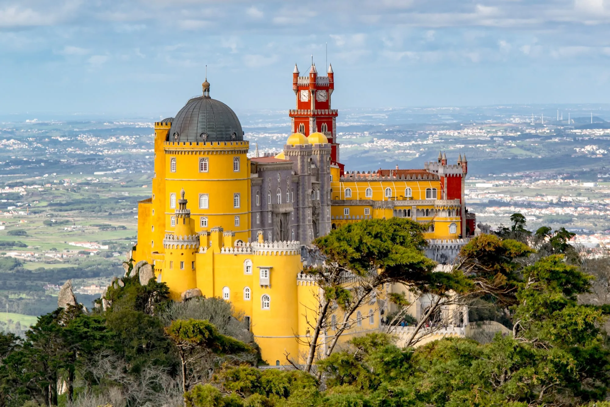 view of pena palace from cruz alta viewpoint, taken on a sintra day trip from lisbon portugal