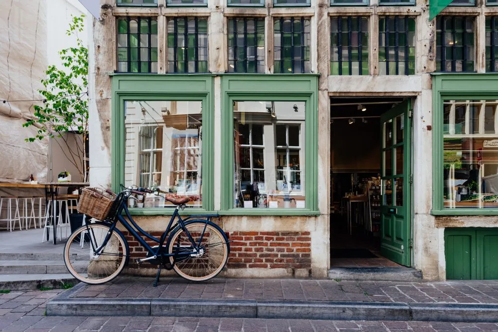 historic building in ghent belgium with green trim and a bicycle parked in front