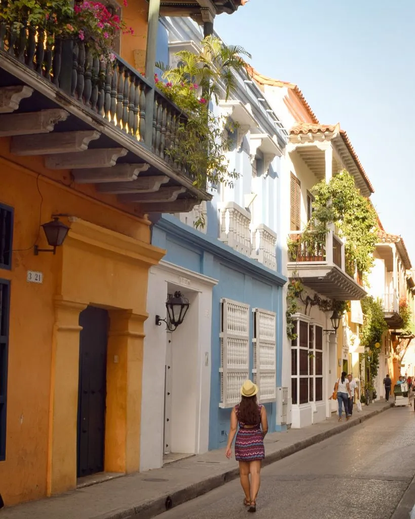 kate storm in a striped dress walking along colorful buildings in cartagena colombia itinerary