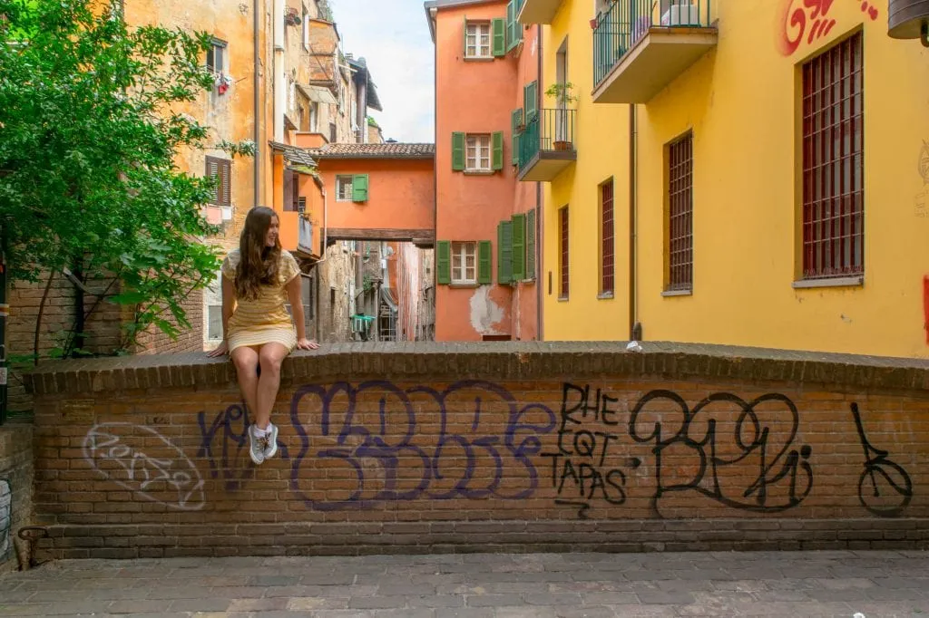 kate storm sitting on a bridge during a day in bologna itinerary