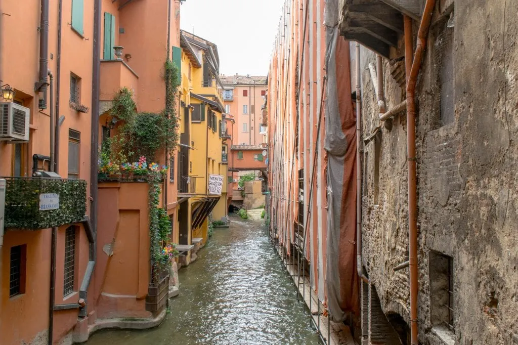 view of a hidden canal surrounded by colorful buildings during a one day in bologna itinerary