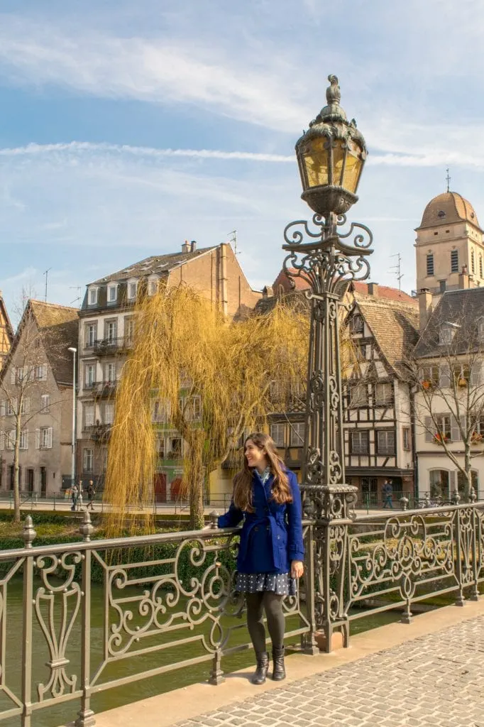 kate storm standing on a bridge overlooking the river when visiting strasbourg france