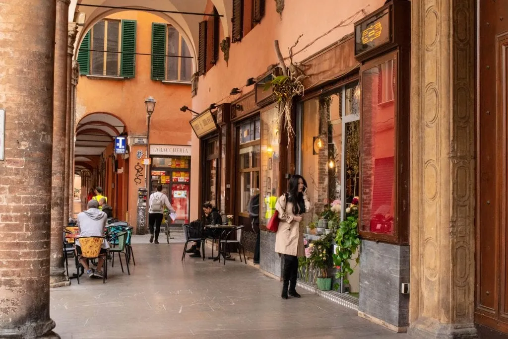 people walking through portico bologna italy