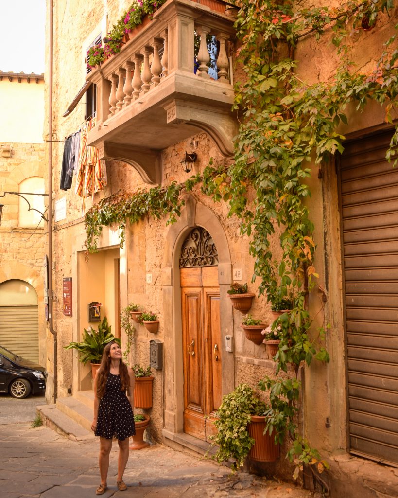 kate storm standing in front of a pretty door and balcony in arezzo italy