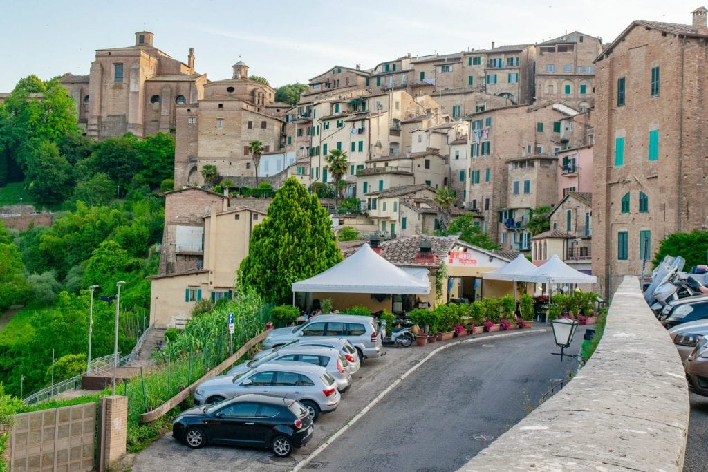 Cars parked outside of Siena Italy--parking outside of historical city centers is the norm when on a Tuscany road trip!