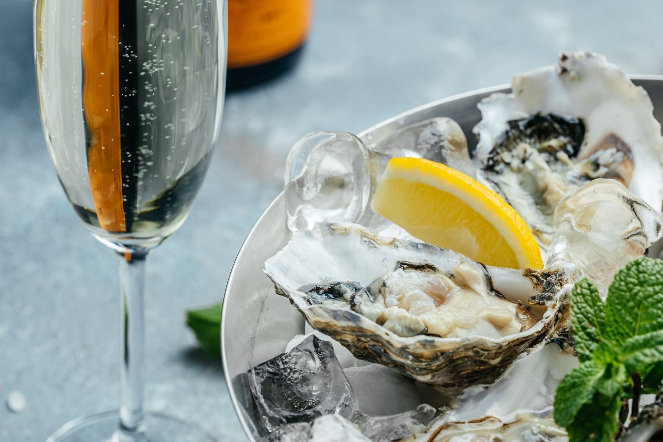 plated oyster on a half shell pictured with white wine