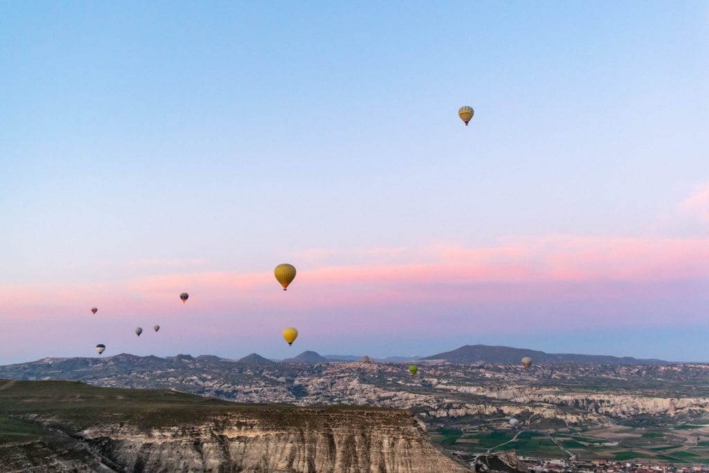 balloons rising over pink and purple sunrise