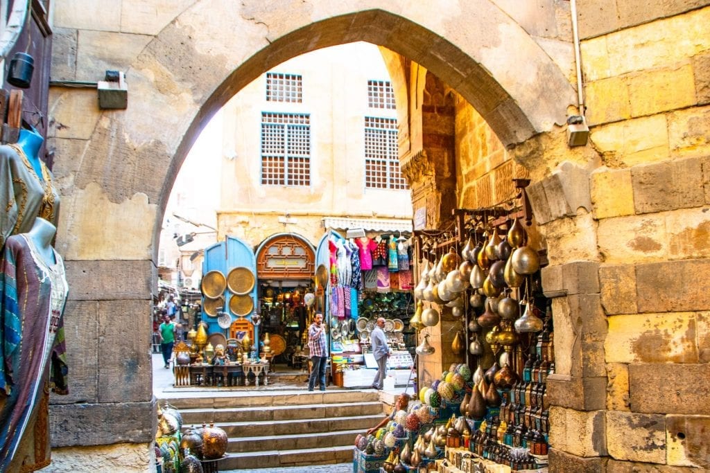 archway of egyptian bazaar with goods for sale on either side