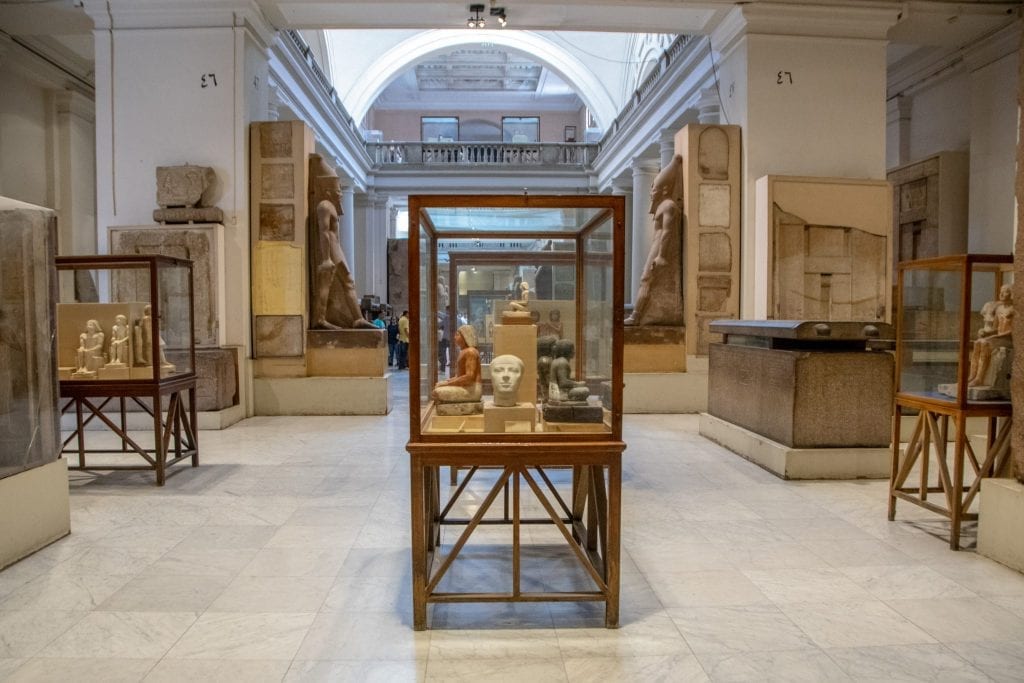 displayes of statues and a sarcophagus in the egyptian museum, as seen when exploring cairo in one day
