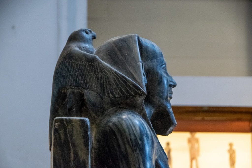 statue of a pharoah with a bird on his back in the egyptian museum in cairo egypt
