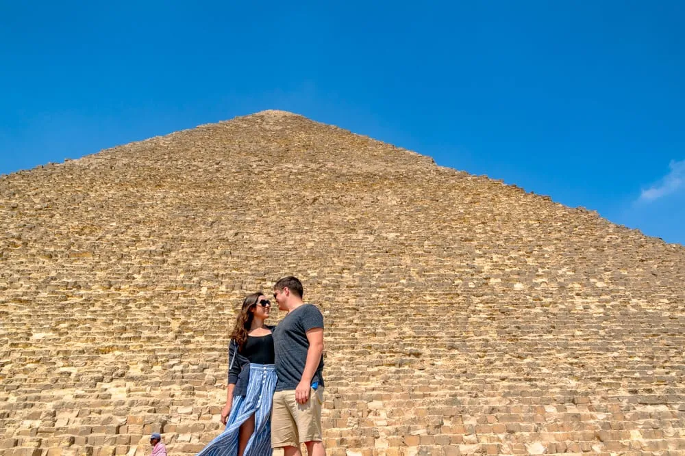 kate storm and jeremy storm standing in front of grand pyramid during a one day in cairo itinerary