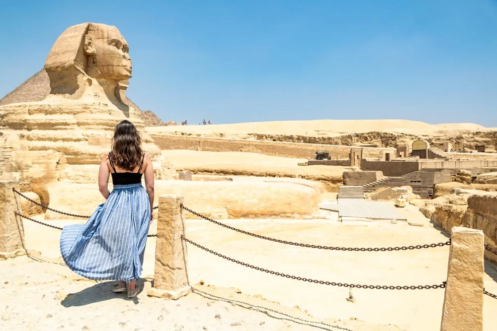 kate storm wearing a blue skirt in front of the great sphinx during a long layover in cairo egypt
