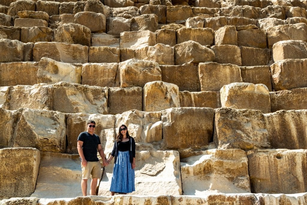 kate storm and jeremy storm standing on the great pyramid of giza in egypt