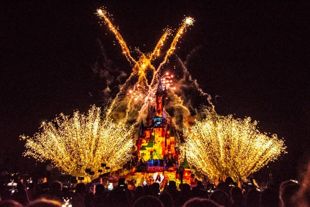 fireworks going off in Disneyland Paris at night above the castle