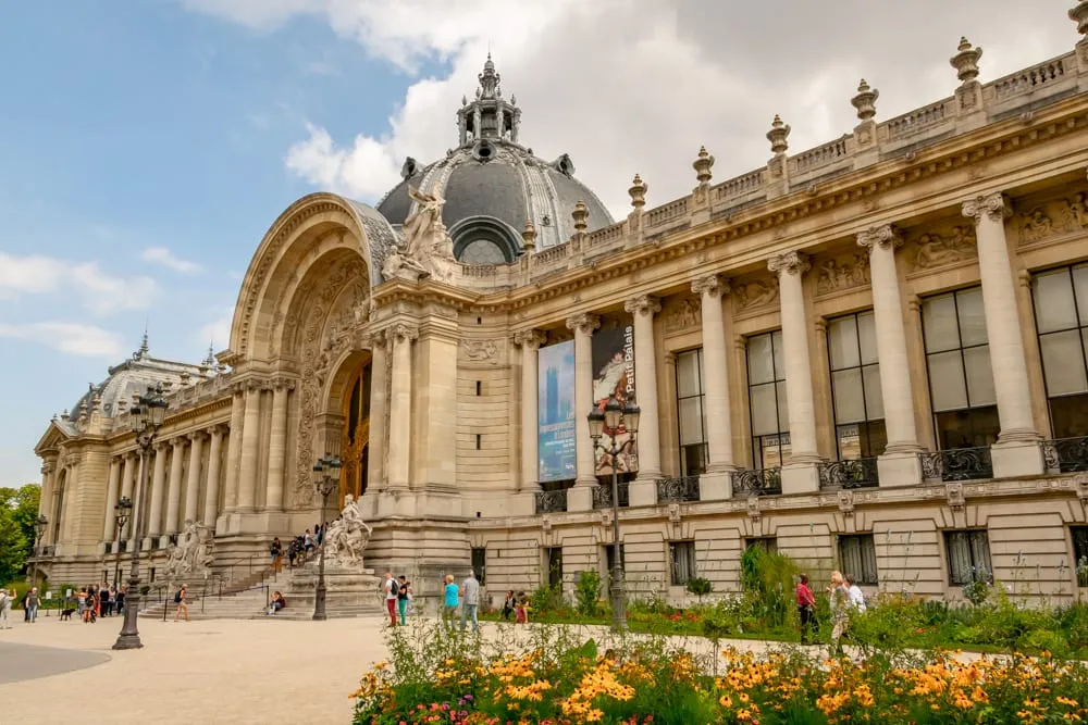 Photo of Petit Palais in Paris in August, with blooming flowers in the righthand corner.