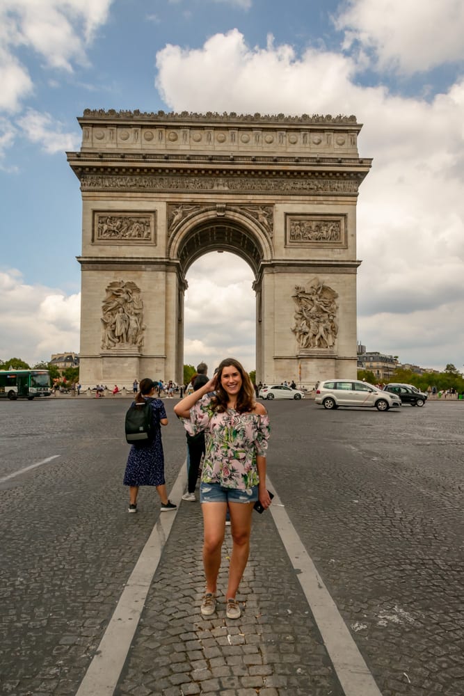 kate storm in the center of the champs elysees with the paris arc de triomphe in the background