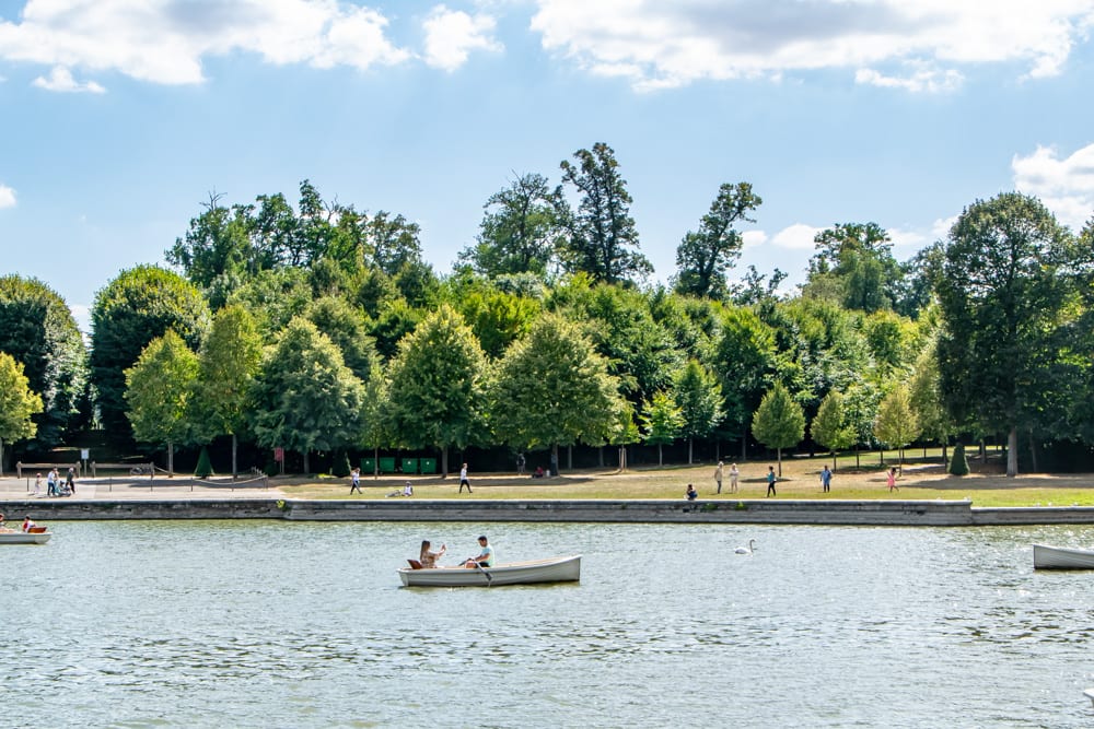 travelers enjoying rowboats in the versailles gardens on a versailles tour